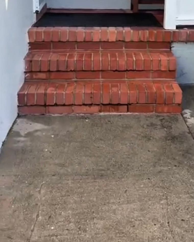 Red brick front steps and a concrete entry walkway