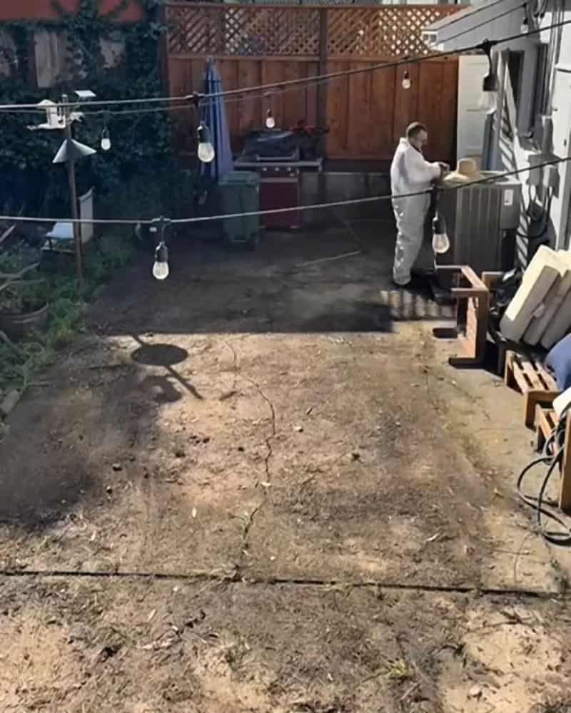 Backyard concrete patio covered in dirt, leaves and debris before cleaning